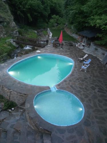 una gran piscina azul con 2 sillas y una mesa en Kyshta za Gosti Gospodevi, en Gorno Dryanovo