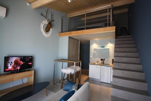 a living room with a staircase leading up to a loft at La Gourgasse Vieille in Béziers