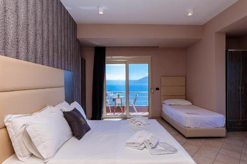 a hotel room with two beds and a balcony at Hotel Aliko in Vlor&euml;