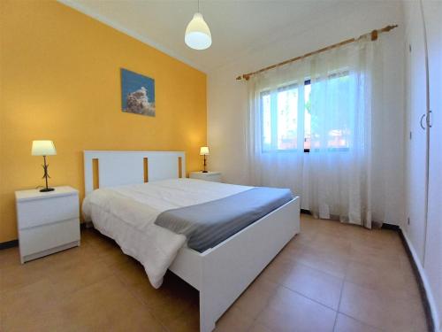 a bedroom with a large bed and a window at Sol Nascente- Piscina, Wifi, Familiar in Vilamoura