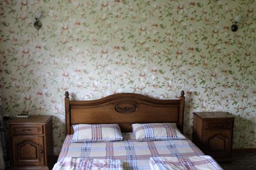 - une chambre avec un lit et un papier peint floral dans l'établissement Уютнейший мини-отель "Rosky", à Yasinya