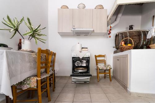 eine Küche mit einem Herd, einem Tisch und Stühlen in der Unterkunft La Casa Cottage in Chania