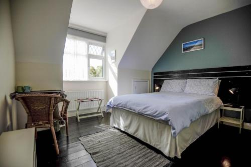 a bedroom with a large bed with a black headboard at BlueTit Lodge in Kilkee