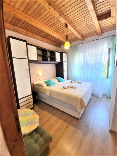 a bedroom with a bed and a chair in it at Apartments Angela in Kampor