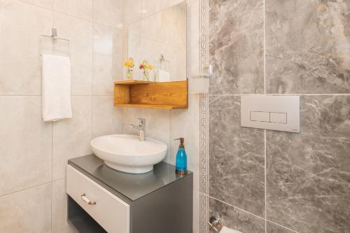 La salle de bains est pourvue d'un lavabo blanc et d'un comptoir avec lavabo. dans l'établissement Huzur Bungalows, à İnlice