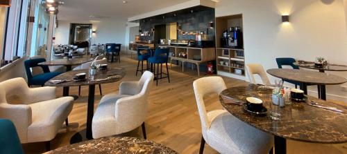a restaurant with tables and chairs and a bar at Hôtel de la Plage - Saint Jean de Luz in Saint-Jean-de-Luz