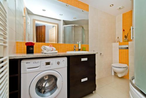 a washing machine in a bathroom with a sink at BlueApart Apartamenty Na Klifie in Władysławowo