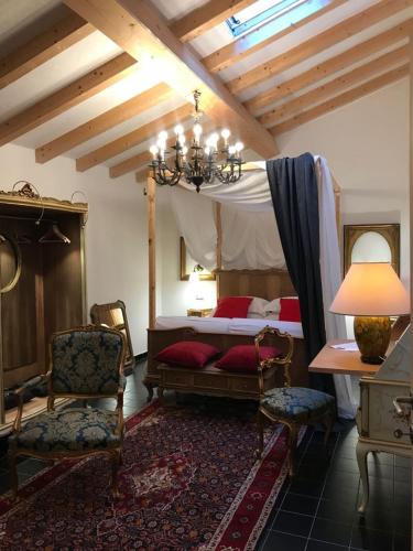 a bedroom with a canopy bed and chairs and a lamp at Sanctus Syrus 2 in Albenga