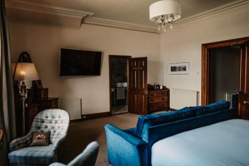 a living room with a bed and a couch and chairs at Shieldaig Lodge Hotel in Gairloch