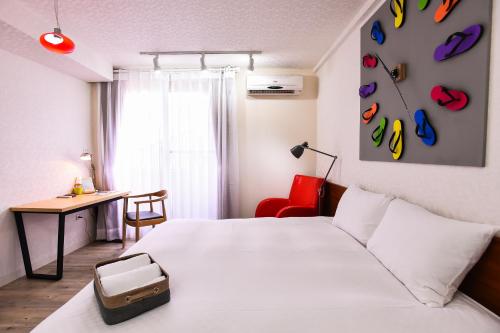 ein Hotelzimmer mit einem Bett mit einem Koffer drauf in der Unterkunft Rainbow Island in Tainan