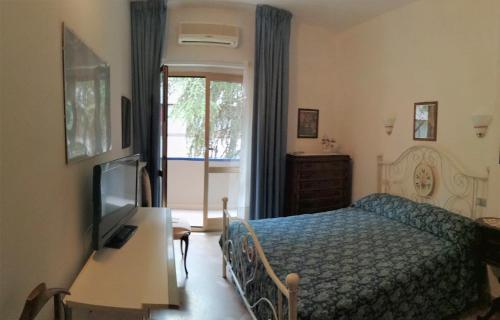 een slaapkamer met een bed, een televisie en een raam bij Maison Dory in Pescara