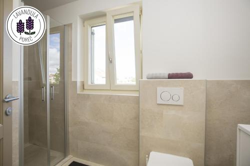 a bathroom with a shower and a toilet and a window at Ferienresidenz Lavandula in Nova Vas
