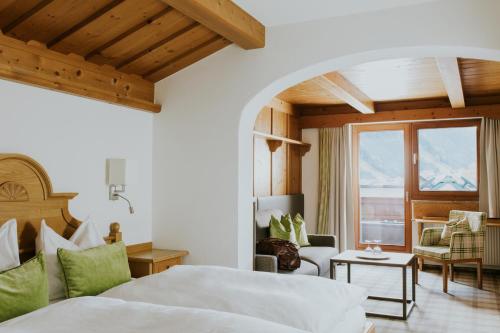 ein Schlafzimmer mit einem Bett und ein Wohnzimmer in der Unterkunft Hotel Tauernhof in Großarl