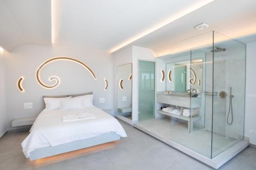 a bedroom with a bed and a glass shower at Aros Luxury Villas in Karpathos Town