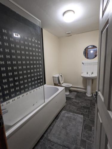 a bathroom with a bath tub and a toilet at Cheap and Cosy Rooms with TV in Clayton le Moors