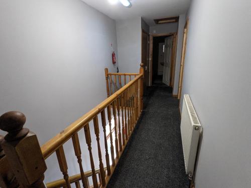 a hallway with a wooden railing and a stair case at Cheap and Cosy Rooms with TV in Clayton le Moors