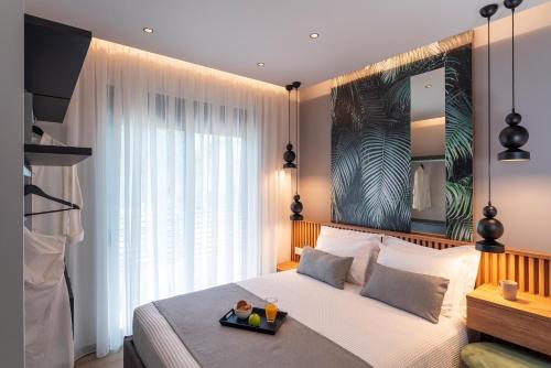 Un dormitorio con una cama con una bandeja de comida. en Palmeral Luxury Suites en Rodas