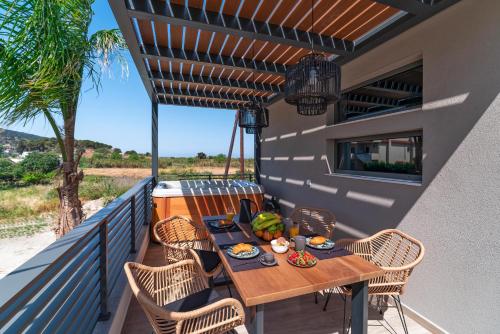 una mesa en el balcón de una casa en Palmeral Luxury Suites en Rodas