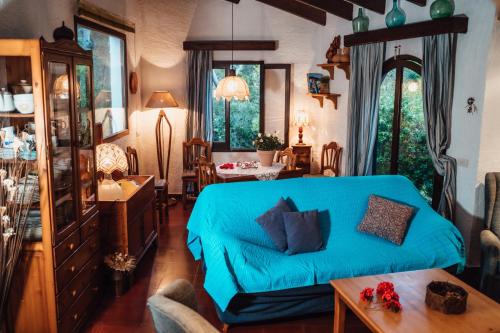 a living room with a blue couch and a table at Villa en Cala Morell con piscina privada en el bosque in Cala Morell