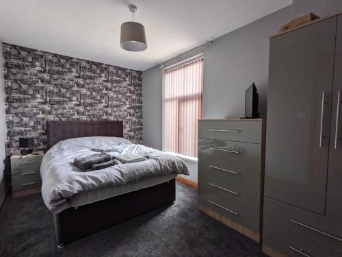 um quarto com uma cama e uma parede de tijolos em Cheap and Cosy Rooms with TV em Clayton le Moors