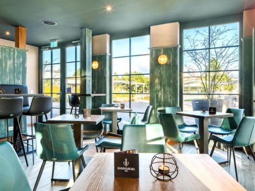 a restaurant with tables and chairs and windows at Premium Haus in Damp