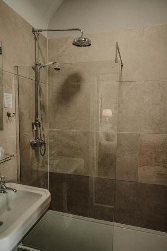 a shower with a glass door next to a sink at Shieldaig Lodge Hotel in Gairloch