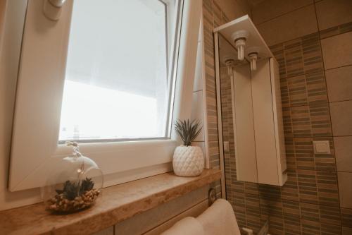 a bathroom with a window and a sink at Perla Apartments in Poreč