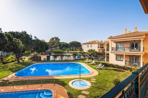 uma vista para uma piscina a partir de uma varanda de uma casa em Quinta Pedra Dos Bicos em Albufeira