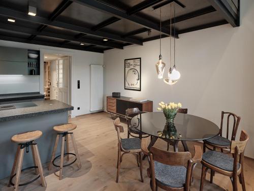 uma cozinha e sala de jantar com uma mesa de vidro e cadeiras em Parcloft em Merano