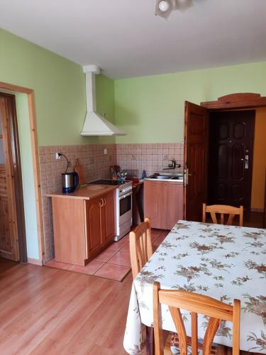 a kitchen with a table and a kitchen with a table and chairs at Apartament Albion in Szklarska Poręba