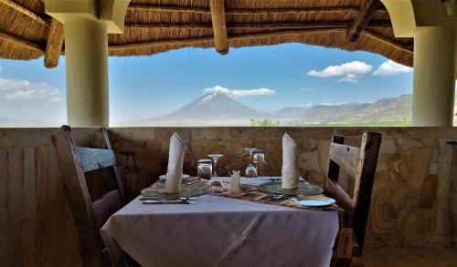 a table with candles and a view of a mountain at Africa Safari Lake Natron in Mtowabaga