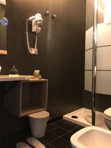 a bathroom with a toilet and a phone on the wall at Sanctus Syrus 2 in Albenga