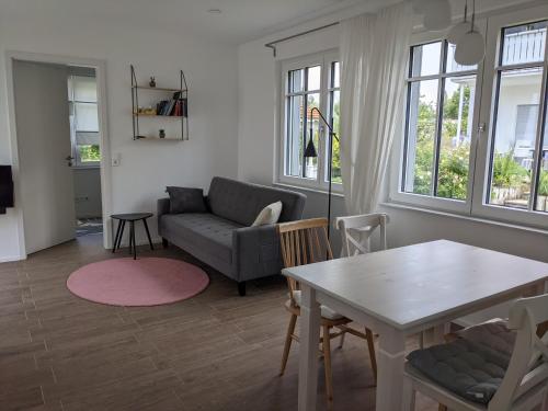 a living room with a table and a couch at Haus zur Aach in Uhldingen-Mühlhofen