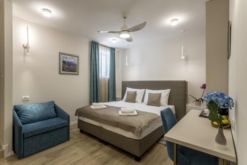 um quarto com uma cama e uma cadeira azul em COR ROOMS em Split
