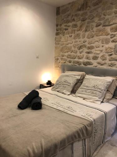 a bed in a bedroom with a stone wall at Maison de naissance de Nostradamus in Saint-Rémy-de-Provence