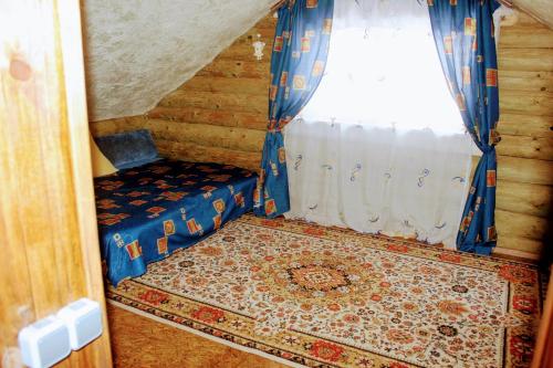 een kleine kamer met een bed en een raam bij Котедж ,,Чудовий"з банькою in Novaya Greblya
