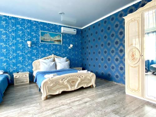 a blue bedroom with a bed and blue walls at Hotel Royal (Отель Роял) in Poltava