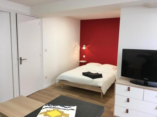 a bedroom with a bed and a flat screen tv at STUDIO DU MARCHÉ in La Rochelle