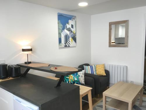 ein Wohnzimmer mit einem Tisch und einem Sofa in der Unterkunft STUDIO DU MARCHÉ in La Rochelle