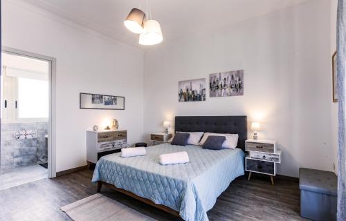 a white bedroom with a large bed and a window at Your Apartment Catania in Catania