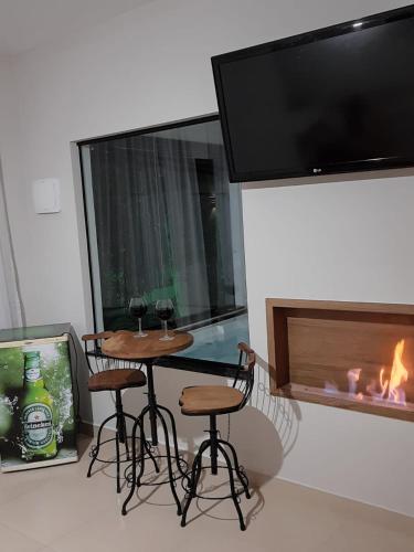 a room with a table and chairs and a fireplace at Pousada Recanto da Cascata in Águas de Lindóia