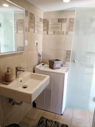 a bathroom with a sink and a washing machine at Casa Bellissima in Chania