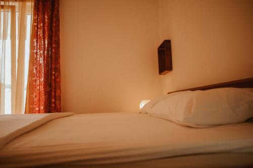a bedroom with a bed with a window and a pillow at Perla Apartments in Poreč