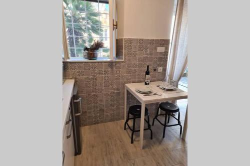 una pequeña cocina con mesa y 2 taburetes en Studio Apartment Marella en Vis