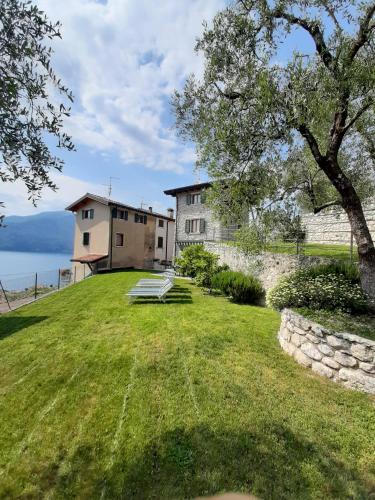 a large grassy yard with a building in the background at Casa/Villa Sommavilla in Brenzone sul Garda