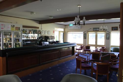 a restaurant with a bar and tables and chairs at Dormie House in Moss Vale