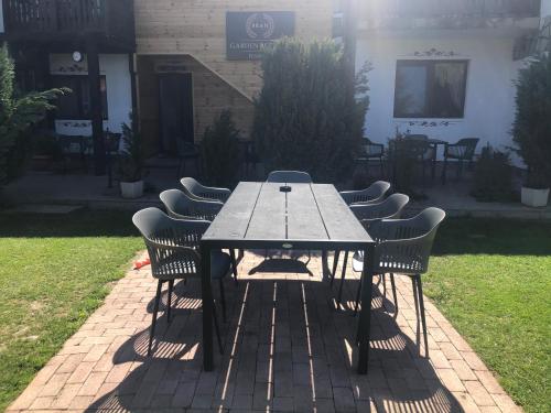 a wooden table with chairs in a yard at Garden Retreat in Bran