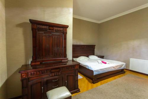 a bedroom with a bed with a wooden dresser and a bed sidx sidx sidx at Apartment Sophie in Kutaisi