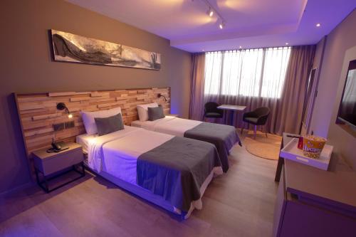 a hotel room with two beds and a television at ÑU Posta Urbana Hotel Boutique in Cordoba