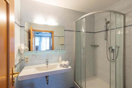 a bathroom with a sink and a shower at Alpenhof Lodge in Saltusio